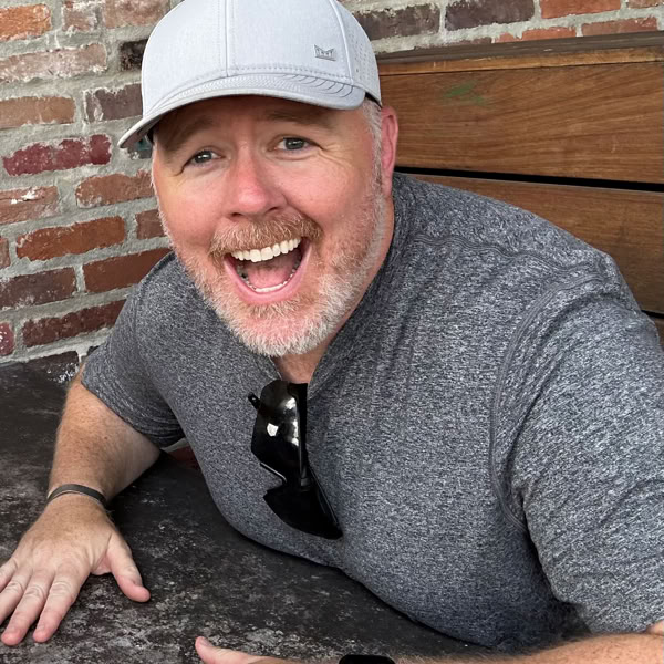 Tattoo artist creating a detailed arm tattoo using modern tools in a studio setting.