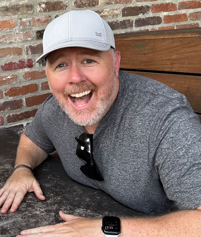 Tattoo artist creating a detailed arm tattoo using modern tools in a studio setting.